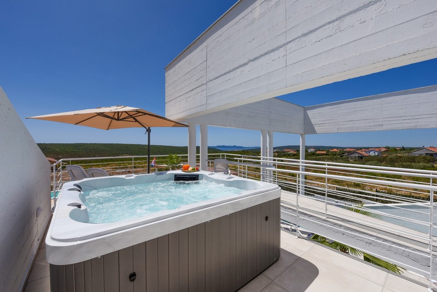 Vasca idromassaggio esterna sulla terrazza superiore con vista sul paesaggio e sul mare.