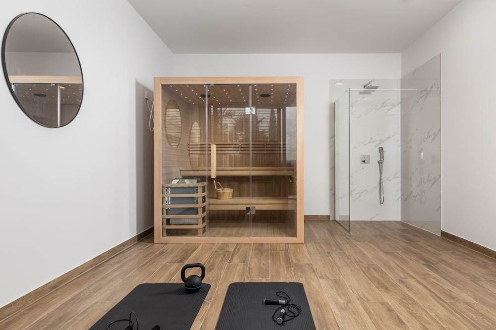 Sauna e area fitness con una doccia.