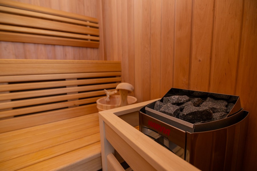 Sauna con rivestimento in legno e camino in pietra