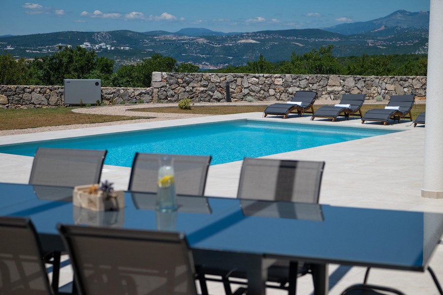 Area esterna con piscina e sedie a sdraio, vista sulle montagne