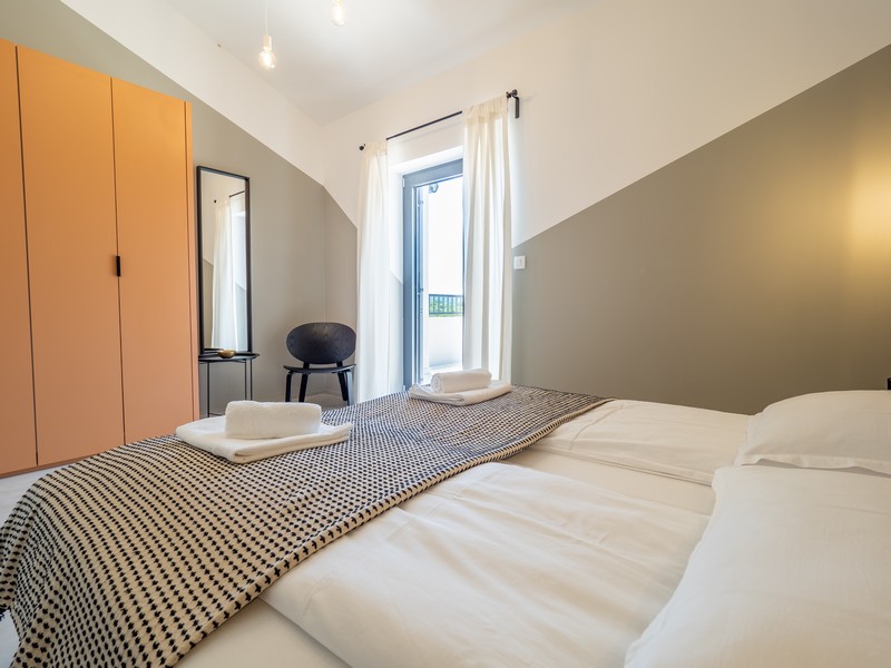 Camera da letto con letto matrimoniale e accesso al balcone