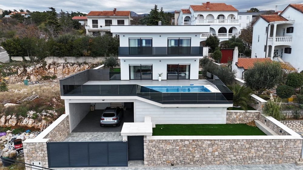 Veduta aerea della villa con piscina sul tetto e carport sotto