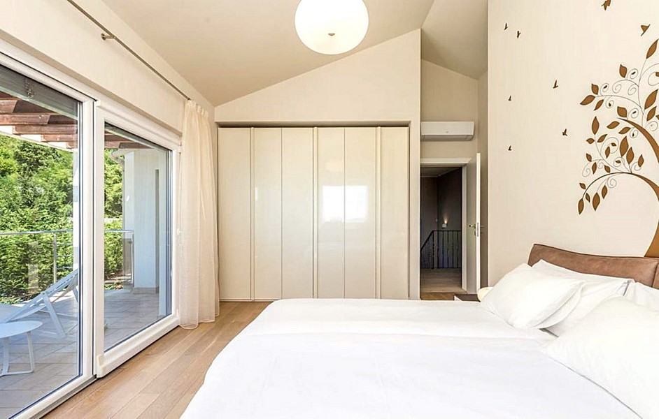 Camera da letto luminosa con balcone e arredamento moderno