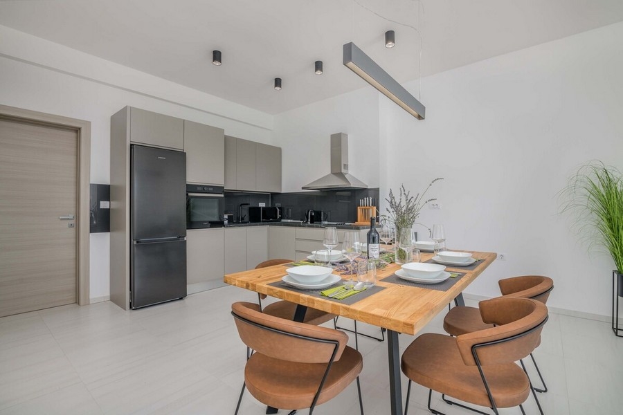 Zona pranzo con tavolo di design e cucina moderna