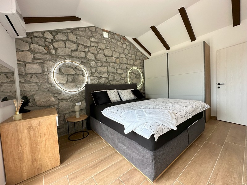 Camera da letto con parete in pietra e accenti moderni