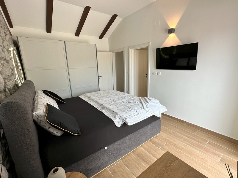 Camera da letto con TV e soffitto in legno