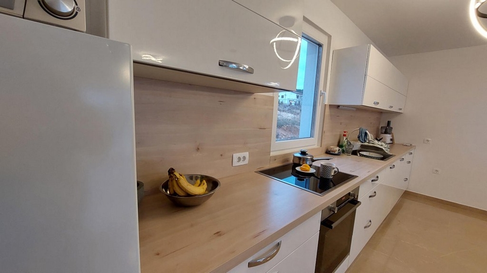 Dettaglio della cucina a incasso con piano di lavoro ed elettrodomestici