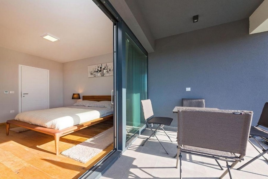 Camera da letto con balcone e vista sul verde