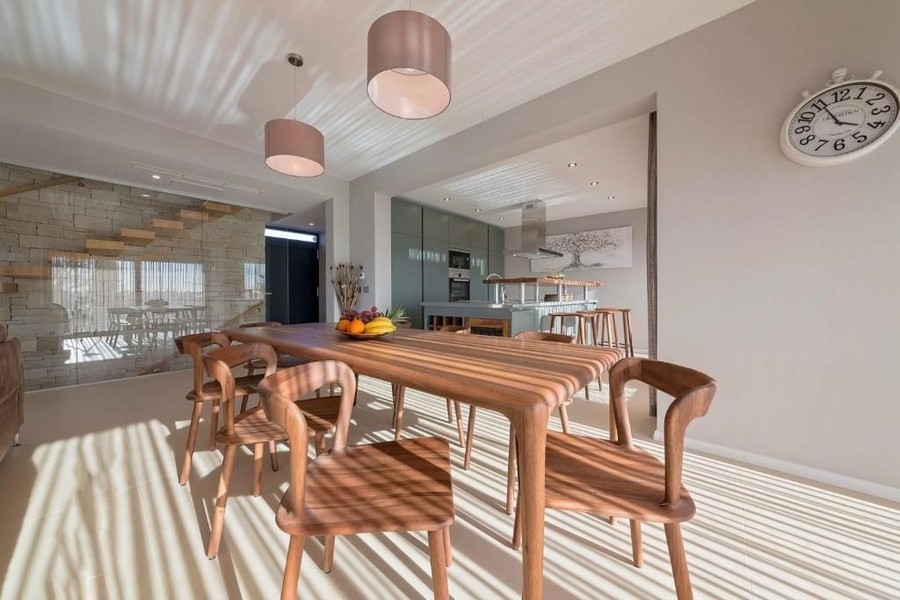 Zona pranzo con tavolo in legno e accesso diretto alla cucina