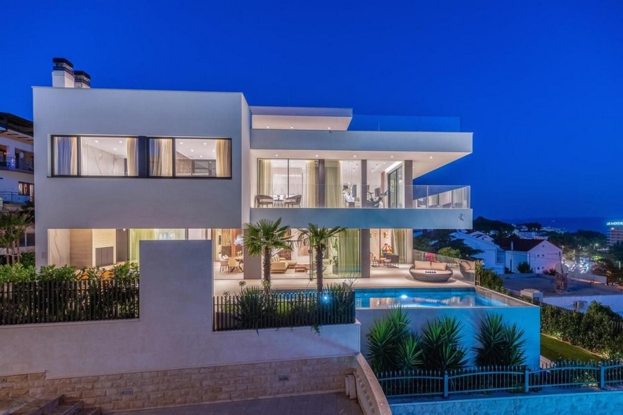 Villa illuminata con palme e piscina nell'ora blu
