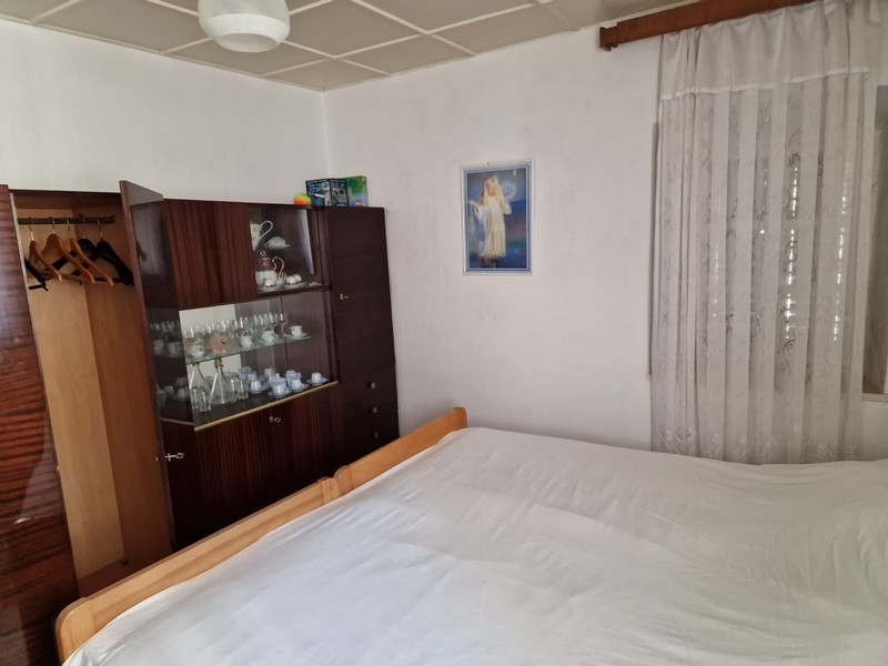 Camera da letto con letto matrimoniale, parete attrezzata e quadro alla parete