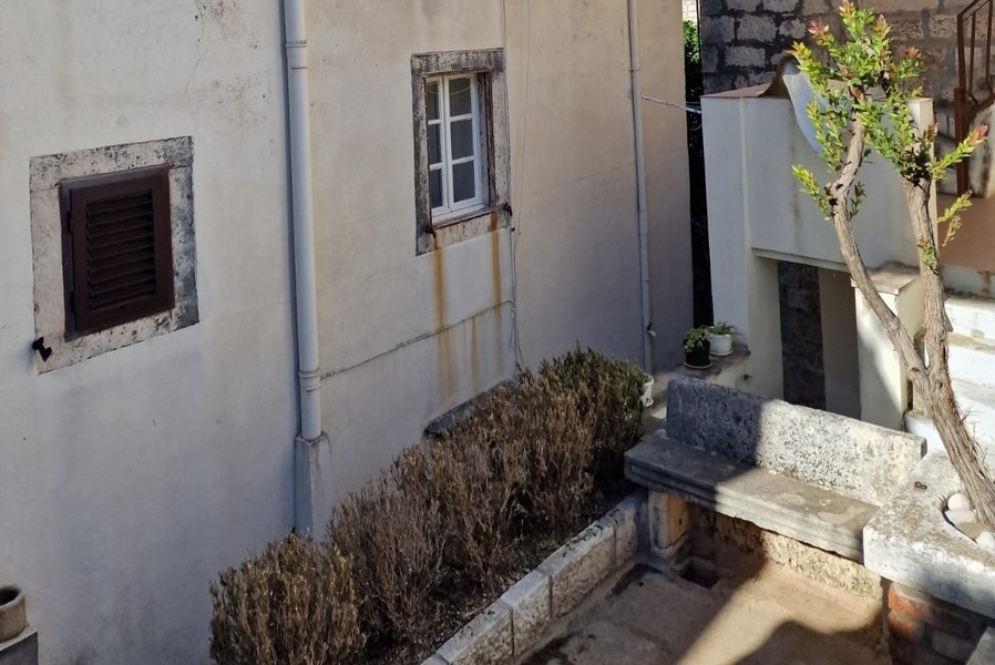 Cortile interno con muri in pietra e piccola panca