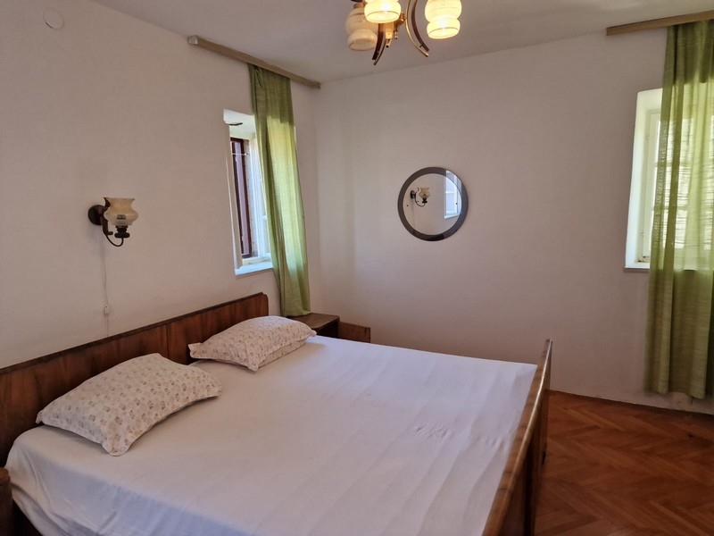 Camera da letto con letto matrimoniale, telaio in legno e tende verdi