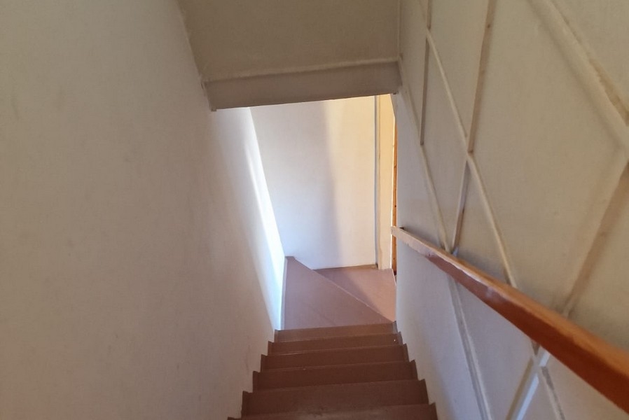 Stretta scala con ringhiera in legno