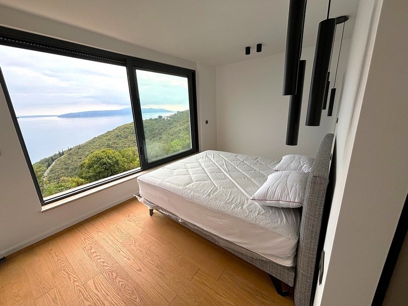 Camera da letto luminosa con grande finestra e vista mare