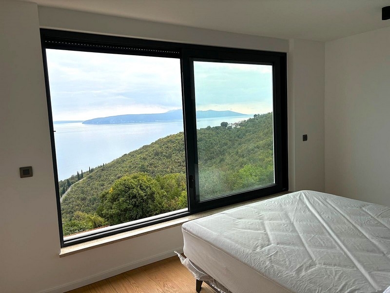 Camera da letto con finestra panoramica e vista mare