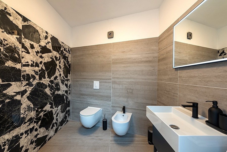 Bagno moderno con grandi piastrelle, lavabo e bidet