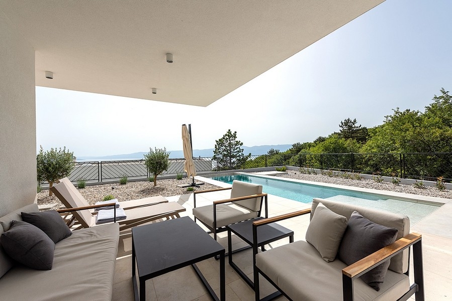Terrazza coperta con zona seduta e piscina, vista mare sullo sfondo