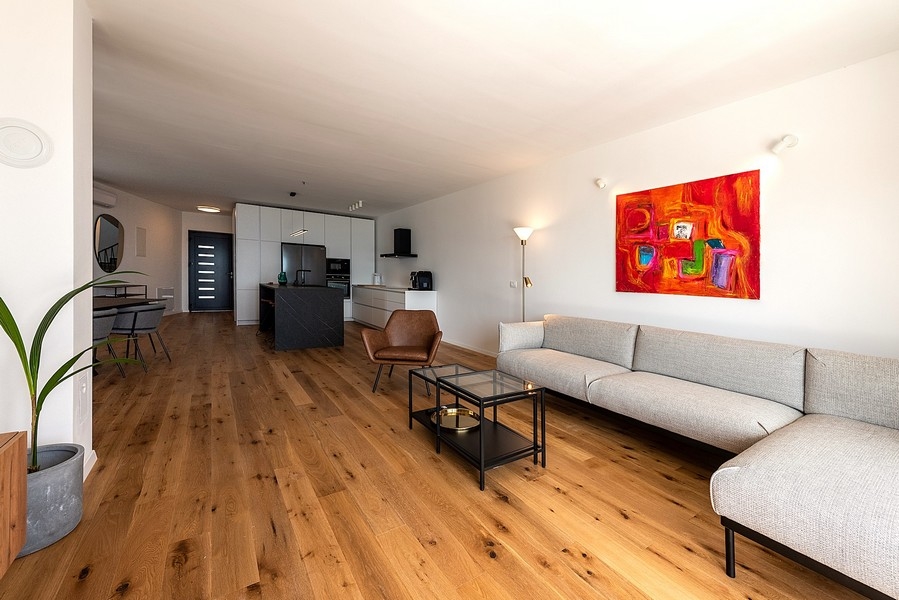 Soggiorno moderno con grande divano, TV e accesso alla terrazza