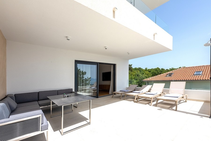 Terrazza coperta con mobili lounge e lettini prendisole