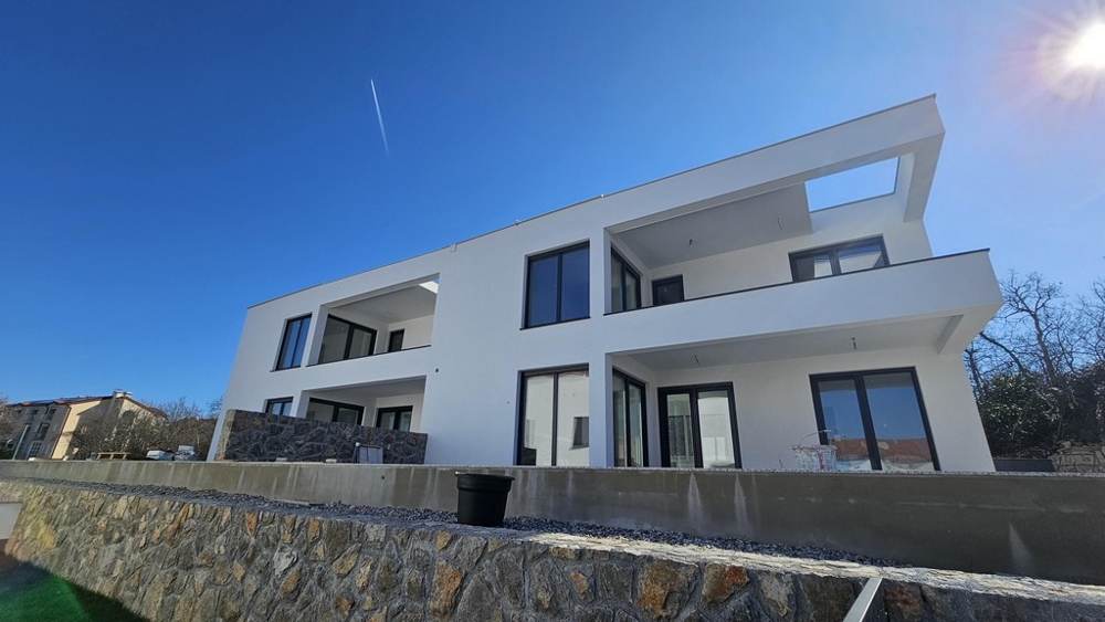 Casa bianca con logge sopra il muro in pietra naturale