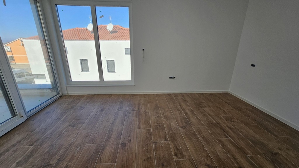 Camera da letto con finestre a tutta altezza e pavimento in legno