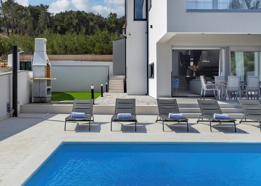 Piscina, solarium e vista sul barbecue.