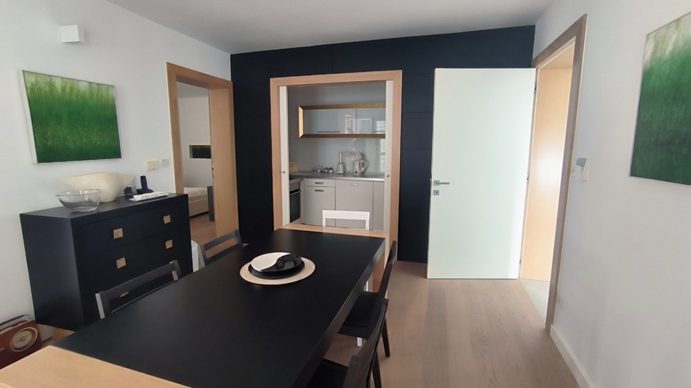 Sala da pranzo con tavolo scuro e collegamento con la cucina