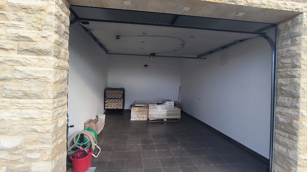 Garage con rivestimento in pietra e pavimento in piastrelle