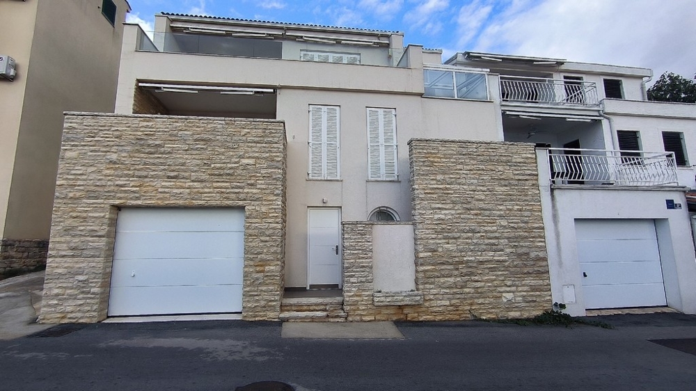 Casa con muri in pietra naturale e garage sulla strada
