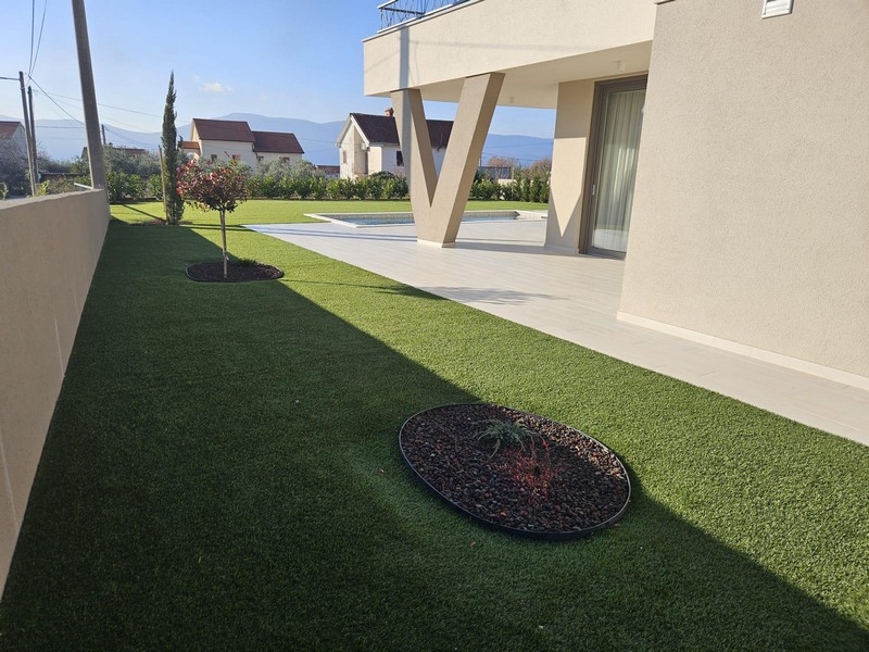 Giardino moderno con prato e terrazza di una villa a Krk