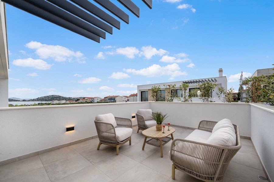 Terrazza moderna con mobili da esterno e vista mare a Tribunj