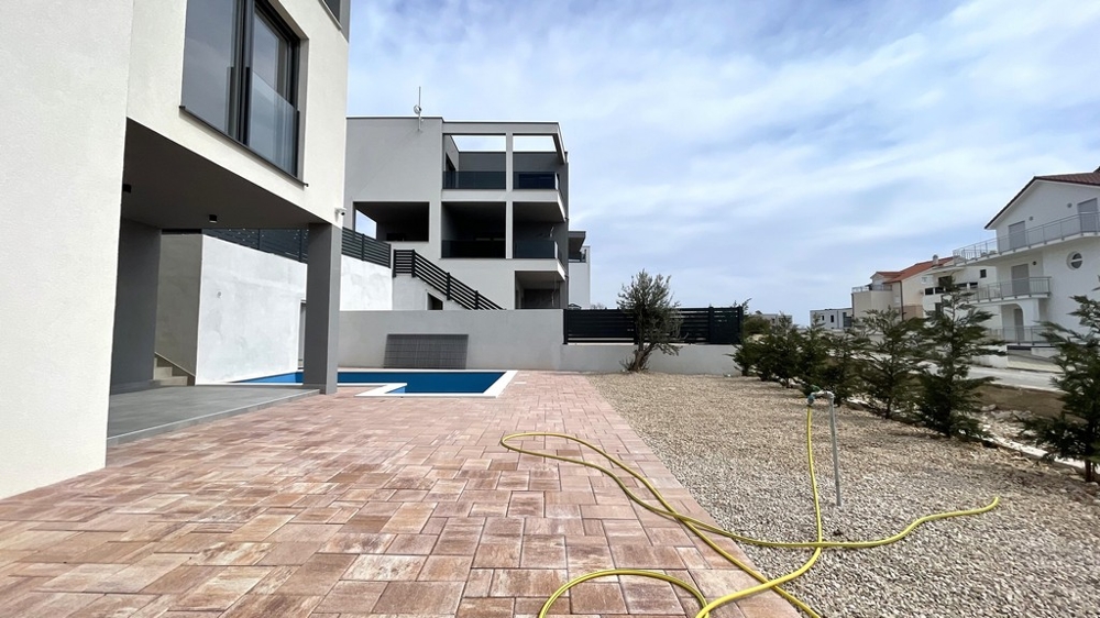 Terrazza moderna con zona piscina e area esterna pavimentata