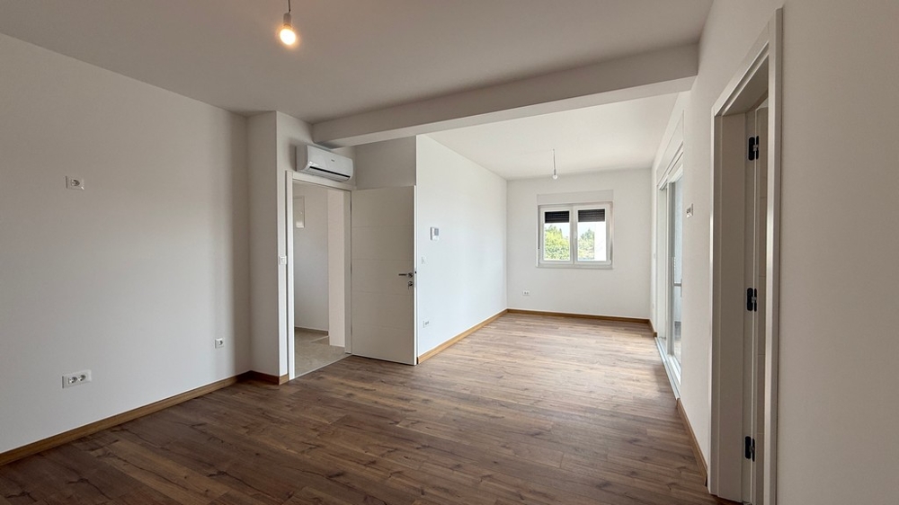 Soggiorno luminoso con parquet e grandi superfici vetrate