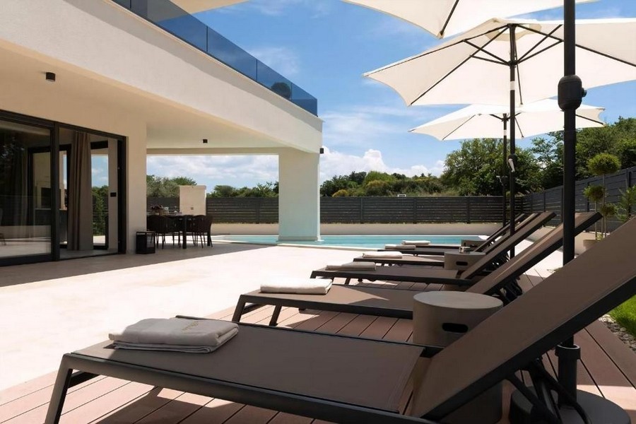 Lettini prendisole sulla terrazza della piscina dell'immobile H3570 vicino a Porec.