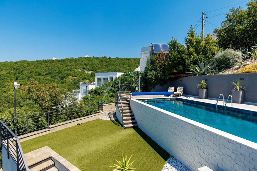 Piscina con prato e scala verso la terrazza - villa in vendita in Croazia