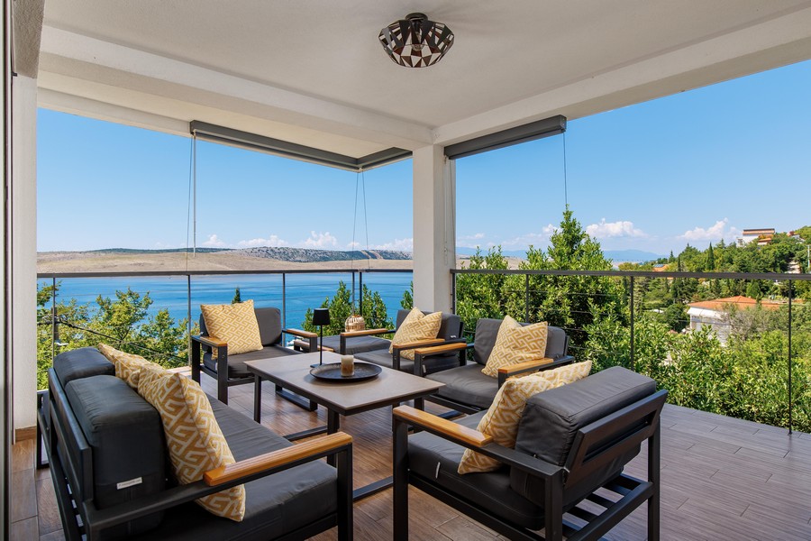 Terrazza coperta con mobili lounge e vista mare