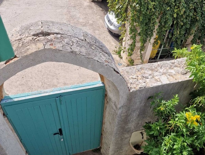 Cancello d'ingresso con arco a tutto sesto e muro