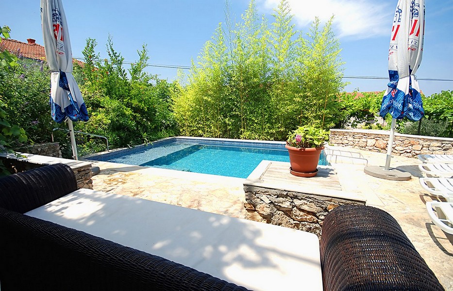 Area piscina con pietra naturale e zona seduta