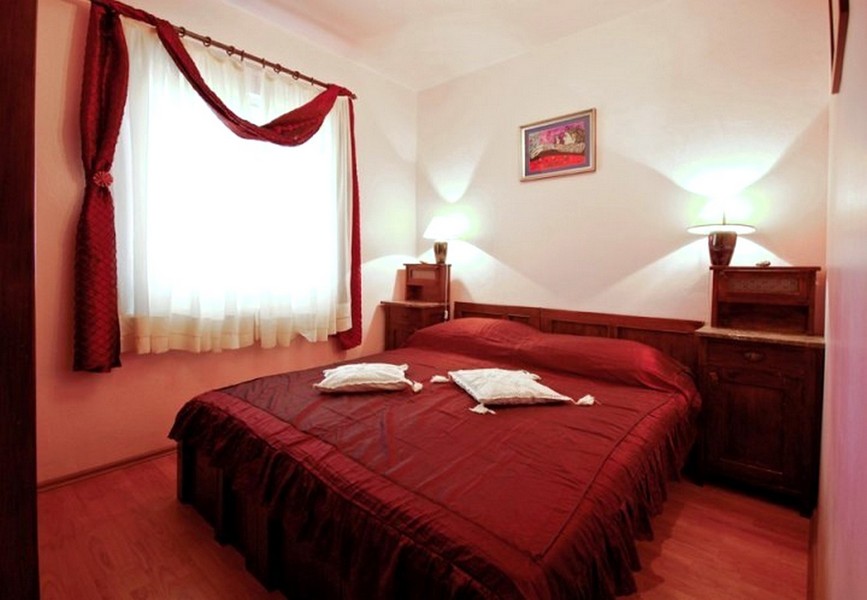 Camera da letto con letto matrimoniale e biancheria rossa