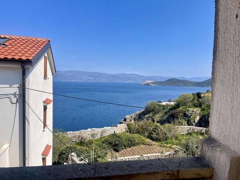 Vista tra le case sulla baia fino all'isola