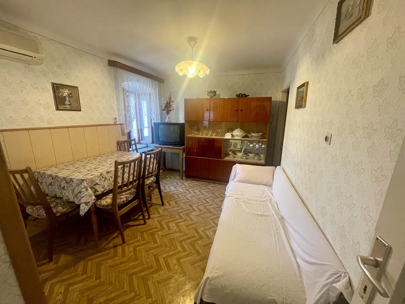 Zona giorno con tavolo da pranzo, divano e vetrina