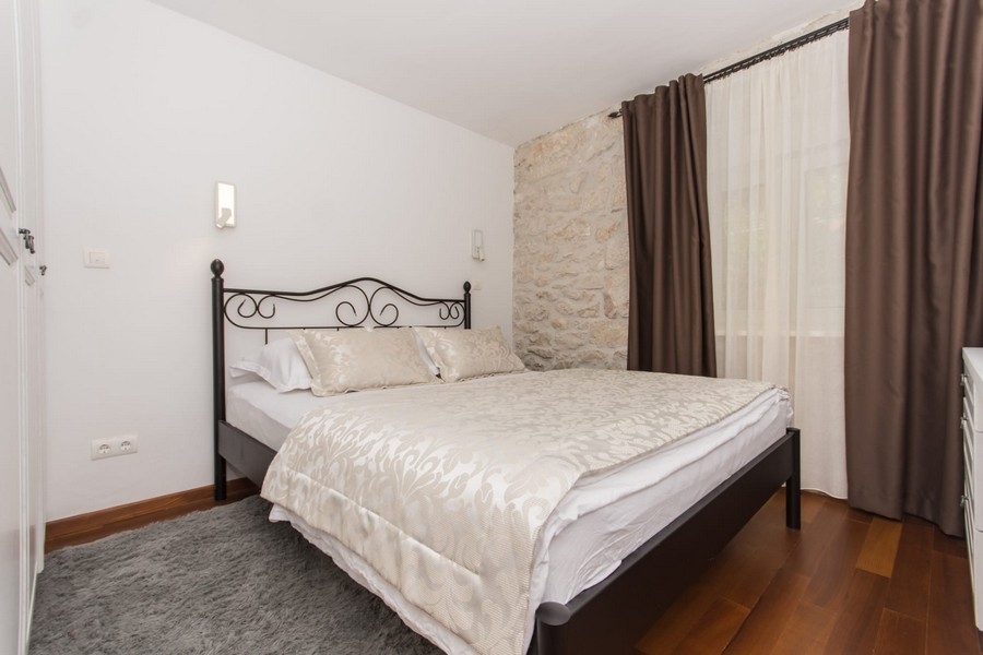 Camera da letto con letto matrimoniale e parete in pietra