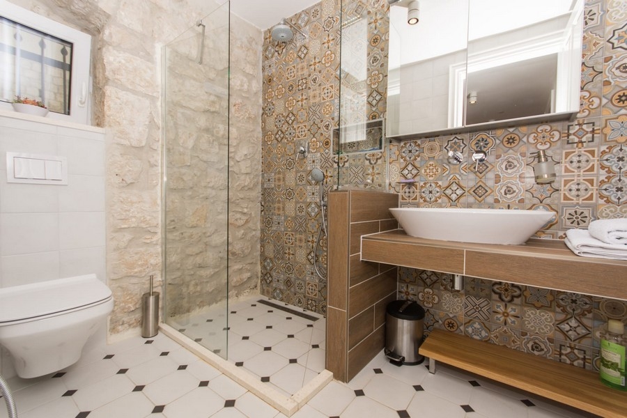 Bagno con doccia, bidet e piastrelle a parete con motivo