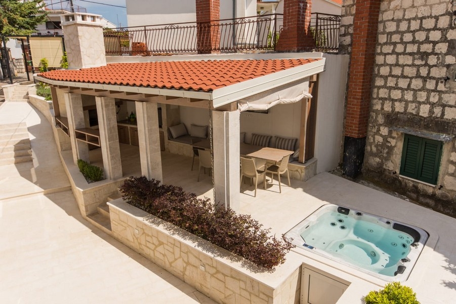Terrazza con vasca idromassaggio e zona seduta coperta