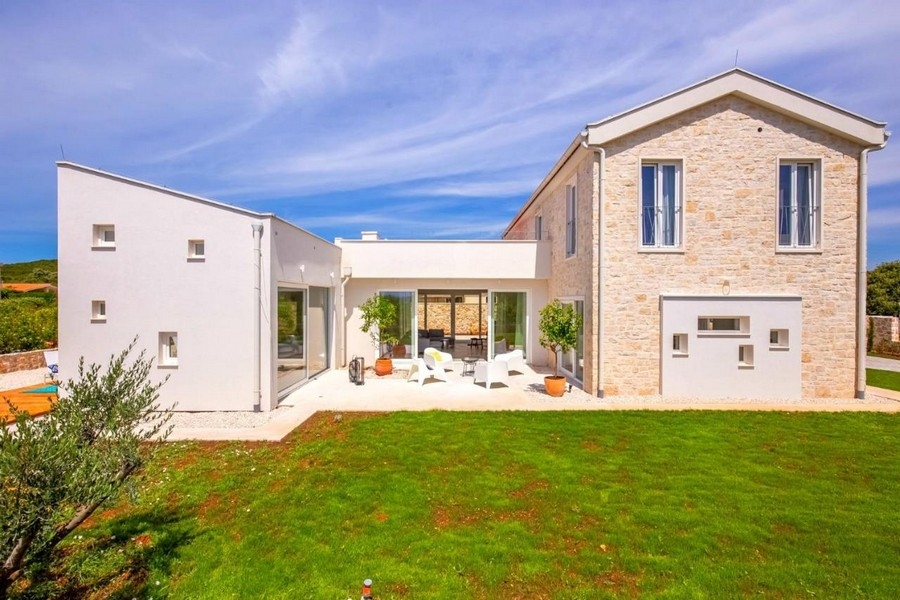 Villa moderna con facciata in pietra naturale e giardino