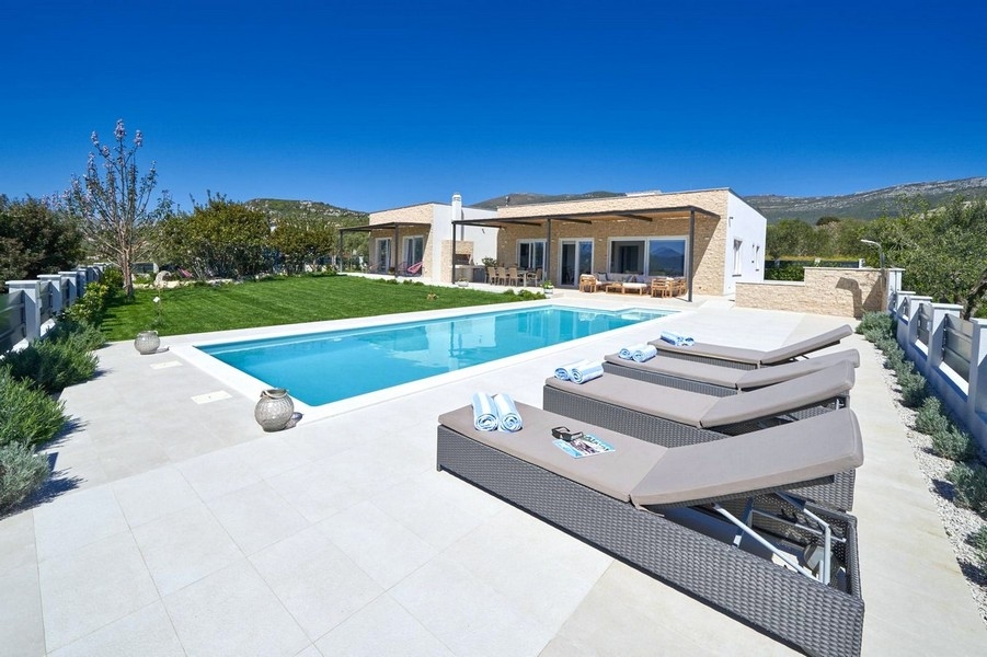 Villa moderna con piscina e lettini di giorno
