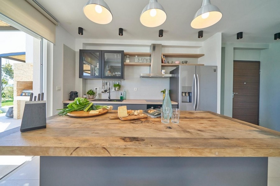 Isola cucina con piano in legno e lampade