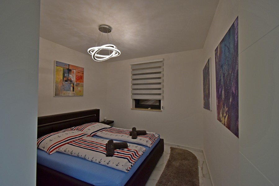 Camera da letto con letto matrimoniale e quadri alle pareti