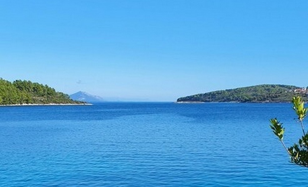 Mare calmo tra due promontori boscosi